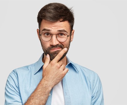 Man on white background wondering about dental bridges in Baltimore