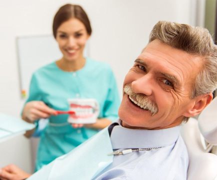 a patient smiling after receiving his new dentures