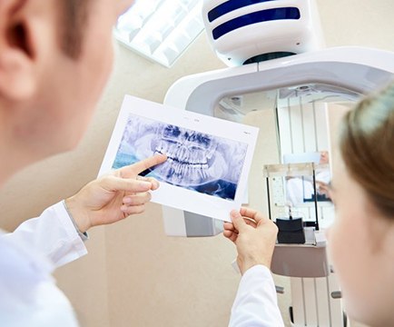 Dentist and patient reviewing her dental X-ray 