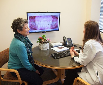 Dentist and patient looking at digital imaging on computer screen