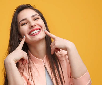 Woman pointing to a healthy smile