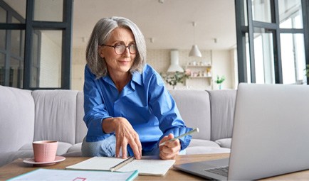 Woman smiling while working on laptop at home