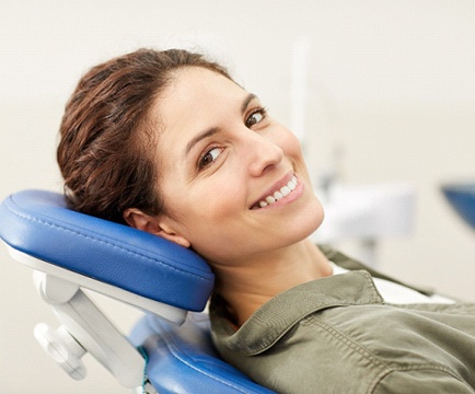 Woman with brown hair smiling in dental chair