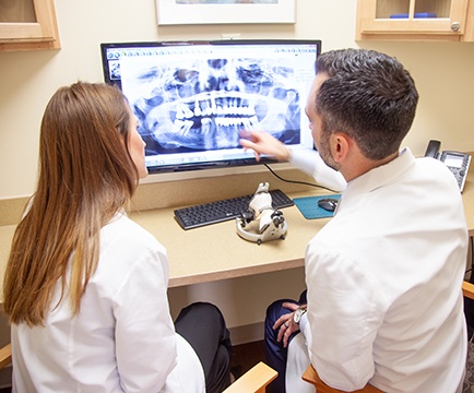 Two dentists looking at digital x-rays