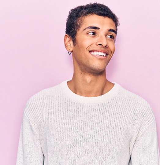 Young man smiling after dental implant failure and salvage in Baltimore