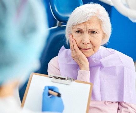 Woman visiting dentist to discuss symptoms of failed dental implants