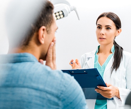 Dentist and patient discussing plan for dental implant salvage