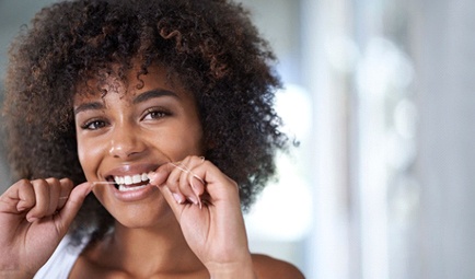 woman flossing her teeth