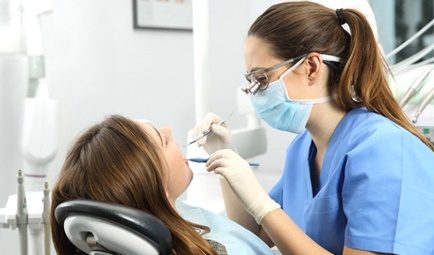 dental hygienist cleaning a patient’s teeth