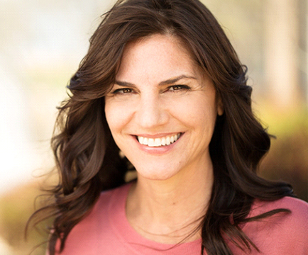 Woman smiling outside with dental implants in Baltimore