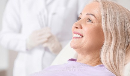 woman smiling while sitting in treatment chair  