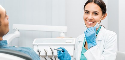 Dentist smiling while giving patient a dental exam