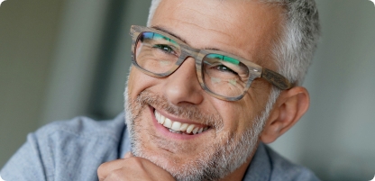 Senior man with glasses grinning