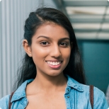 Young woman in denim shirt smiling outdoors