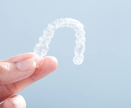 patient holding Invisalign in Baltimore
