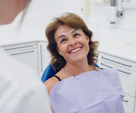 Middle-aged patient looking up at her dentist