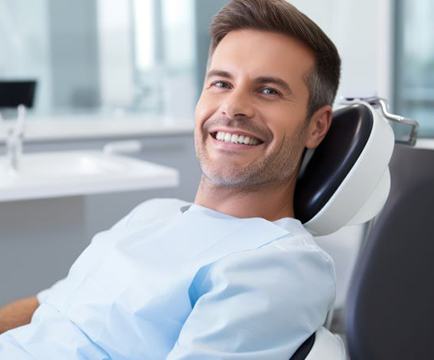 Happy male patient in dental treatment chair