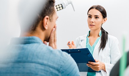 A dentist assessing her patient for oral conscious sedation