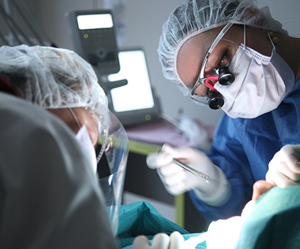 Dental team carefully performing oral surgery