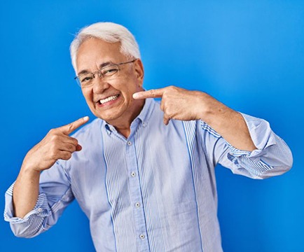 Happy older man pointing at his smile