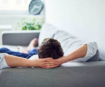Man relaxing at home on his sofa