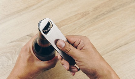 Closeup of patient using bottle cap opener