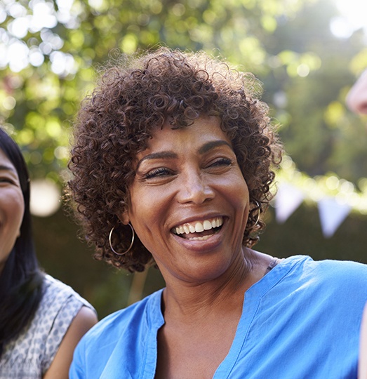 Woman smiling after replacing missing teeth