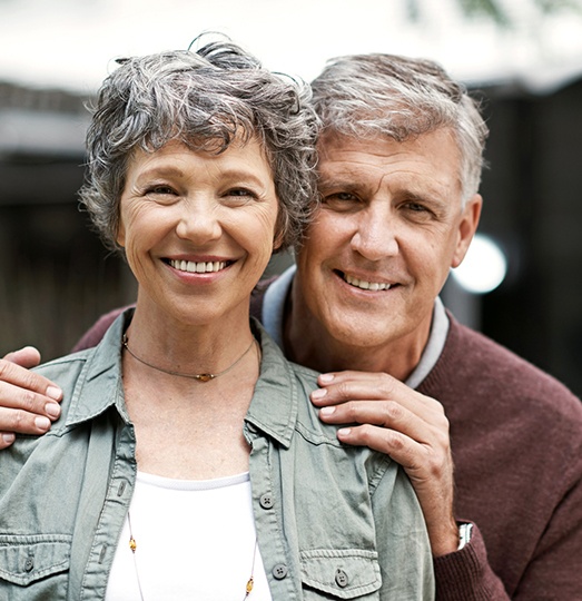 Man and woman smiling after restorative dentistry