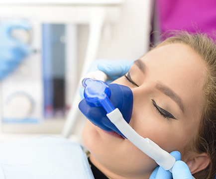 Relaxed woman with nitrous oxide dental sedation mask in place