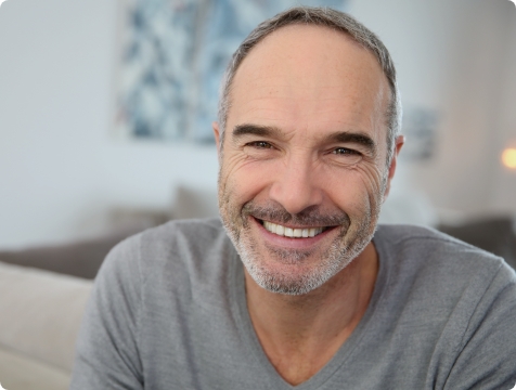 Man smiling after replacing missing teeth