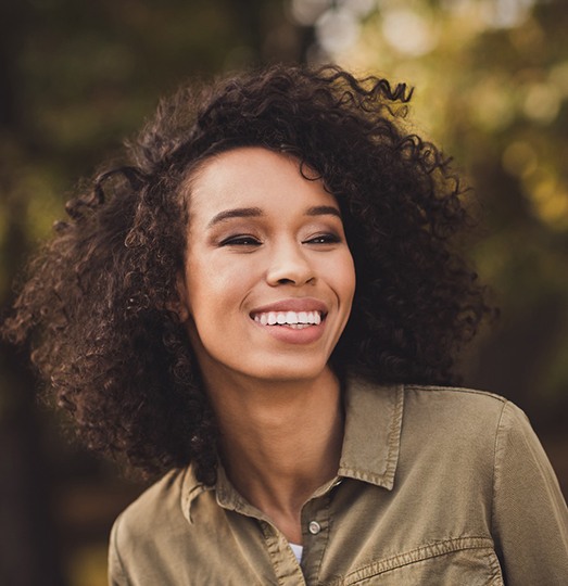 Woman outside smiling with porcelain veneers in Baltimore, MD