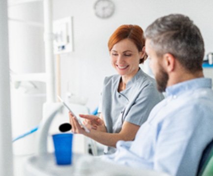 Cosmetic dentist explaining cost of teeth whitening to patient