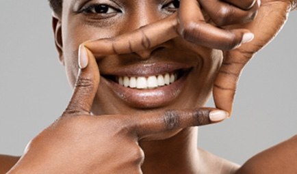 woman using her fingers to frame her beautiful smile