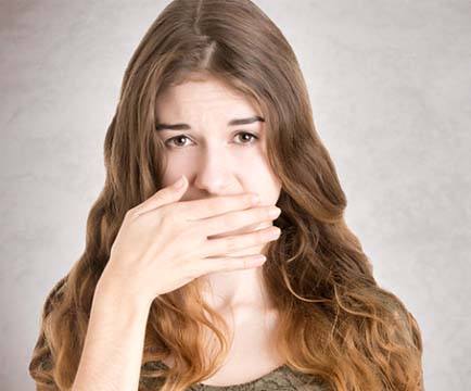 Woman covering mouth before teeth whitening in Baltimore