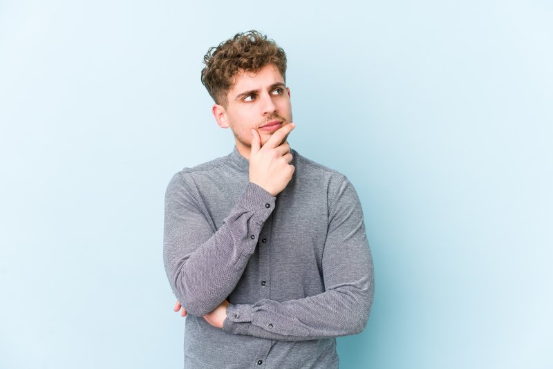 A man wondering about the difference between Invisalign and veneers