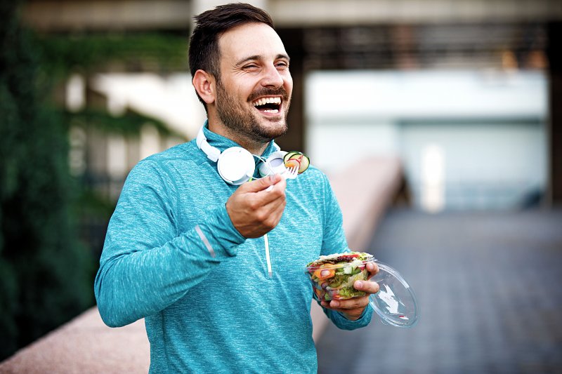 A man enjoying a salad with new dental implants
